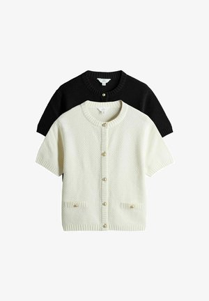 Kortærmet cardigansæt i creme og sort. Struktureret strik, rund hals, perleknapper og to forlommer med ribkant.