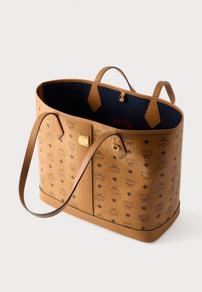 Καφέ δερμάτινη τσάντα tote με μοτίβο λογότυπου, επίπεδες λαβές και ανοιχτή εσωτερική επένδυση σε μπλε χρώμα με χρυσές λεπτομέρειες εξαρτημάτων.