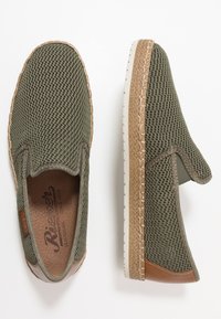 Groene instap schoenen met een mesh bovenkant, een gestructureerde rubberen zool en bruine leren accenten. Kenmerkend is het gestikte ontwerp langs de zool.