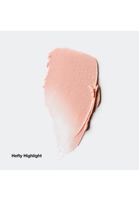 Échantillon de highlighter cosmétique crémeux de couleur pêche rosée avec une finition lisse et légèrement texturée sur fond blanc.