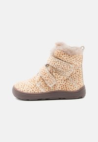 Brune og beige, lodne ankelstøvler med et prikket mønster, der har to justerbare Velcro-stropper, tekstureret overflade og en rund tå.