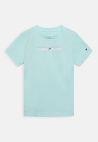 Light blue cotton t-shirt with short sleeves, featuring the "TOMMY HILFIGER" logo in gradient print across the chest and a small logo on the sleeve.
