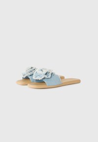 Blue denim slide sandals with frayed floral accents and a beige rubber sole. Open-toe design with a casual, flat profile.