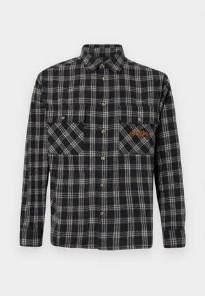 Plaid flannel shirt in navy and cream with gold buttons, two chest pockets, and orange logo detail on the left pocket.
