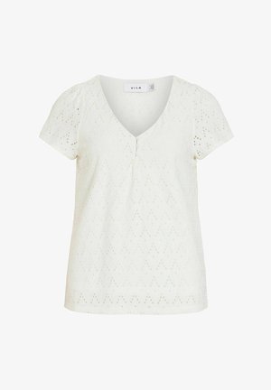 Blusa blanca de manga corta con cuello en V, pequeños botones forrados de tela y patrón de ojales en zigzag por toda la prenda.