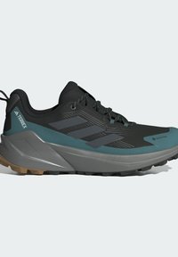 Schwarzer und türkisfarbener Wanderschuh aus Gore-Tex-Material, mit strukturiertem Obermaterial, Dreistreifen-Design und robustem Gummisohle für Halt.