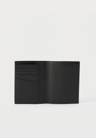 Μαύρο δερμάτινο πορτοφόλι ανοιχτό επίπεδα που δείχνει τέσσερις θέσεις για κάρτες και δύο μεγαλύτερες θήκες πάνω σε απλό λευκό φόντο.