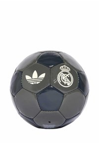 Balón de fútbol gris y azul marino hecho de cuero brillante. Presenta el logo blanco de Adidas y el emblema del Real Madrid. Paneles hexagonales con textura suave.
