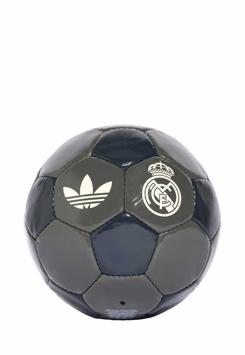 Balón de fútbol gris y azul marino hecho de cuero brillante. Presenta el logo blanco de Adidas y el emblema del Real Madrid. Paneles hexagonales con textura suave.