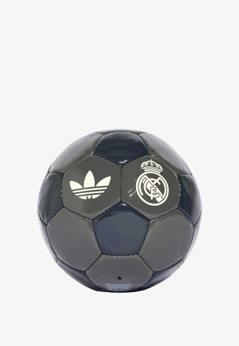 Balón de fútbol gris y azul marino hecho de cuero brillante. Presenta el logo blanco de Adidas y el emblema del Real Madrid. Paneles hexagonales con textura suave.