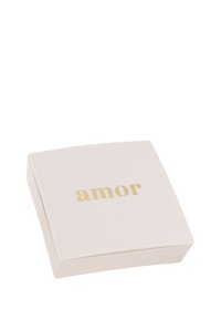 Liten fyrkantig beige låda med ordet "amor" i guld centrerat på locket, stängd och vilande på en vit yta.