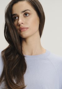 Maglione blu chiaro lavorato a maglia con scollatura rotonda, caratterizzato da dettagli di cucitura testurizzati lungo le maniche e una finitura in tessuto liscia.
