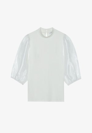 Fehér felső rövid, átlátszó puffos ujjakkal, kerek nyakkal és hátoldali gombos záródással. Sima textúra, tiszta, minimalista dizájnnal.