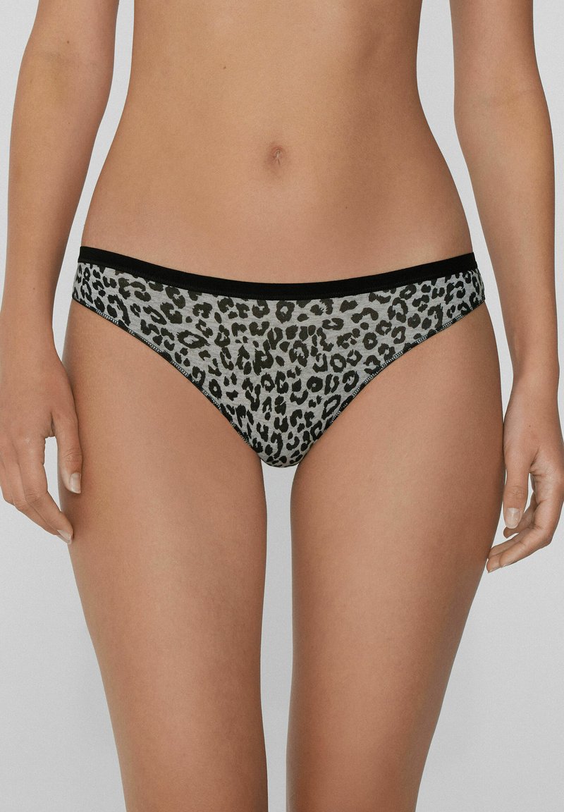 Leopardenmuster-Unterwäsche aus glattem Stoff mit einem schwarzen Bund und einem kontrastierenden grauen Hintergrund. Das Design hebt ein verspieltes Muster hervor.