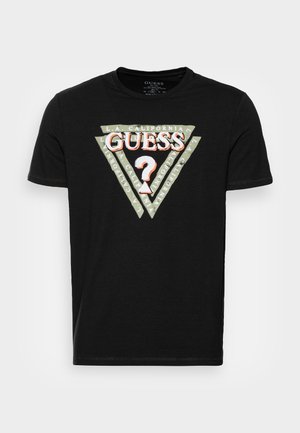 T-shirt en coton noir avec un graphique triangulaire comportant le texte "GUESS" et "L.A. CALIFORNIA" imprimé autour. Manches courtes, col rond.