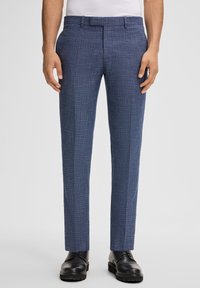Pantaloni sartoriali blu navy con un motivo testurizzato, davanti piatto, passanti per la cintura e una vestibilità slim, abbinati a scarpe eleganti nere.