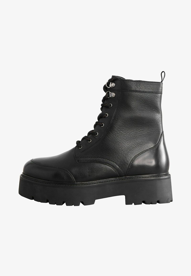 Bottines en cuir noir avec une finition texturée, fermeture à lacets à l'avant, bout rond, semelle en caoutchouc épaisse et petite languette à l'arrière.
