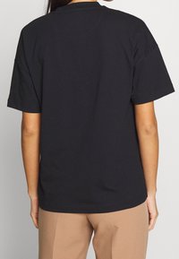 Zwart katoenen t-shirt met korte mouwen en een ronde hals. Heeft een effen achterkant zonder zichtbare logo's of patronen. Zachte textuur.