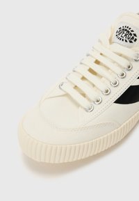 Leinen-Sneakers in Off-White mit schwarzem Seitenstreifen, ausgestattet mit silbernen Ösen, runder Zehenform und strukturiertem Gummisohle mit gerippten Akzenten.