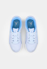 Une paire de chaussures de sport bleu clair avec des lacets, une doublure intérieure bleue et un logo en silhouette visible sur la semelle intérieure et la languette, vue de dessus.