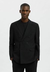 Mustmustaritud kahekordne blazer, mis on valmistatud tekstuuriga kangast, millel on soonilised kraed, kaks esist pocketit ja kuue nööbiga kinnihoidmine.