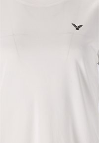 Hvid kortærmet t-shirt med rund halsudskæring, struktureret stof og et lille sort logo på venstre side af brystet.