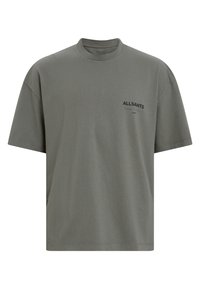 Camiseta de algodón gris de manga corta con cuello redondo y un pequeño logo impreso en negro en el área del pecho izquierdo. Corte holgado y textura suave.