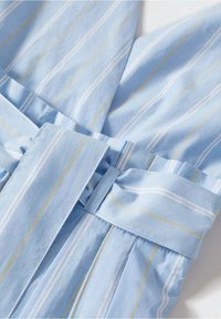 Robe en tissu bleu clair avec des rayures verticales blanches et jaunes, dotée d'une ceinture à la taille, de détails plissés et d'une texture lisse.