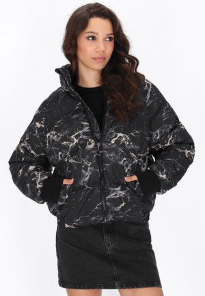 Puffer jacket in black with a marble pattern featuring beige accents. Zipper closure, high collar, and side pockets. Soft, quilted texture.