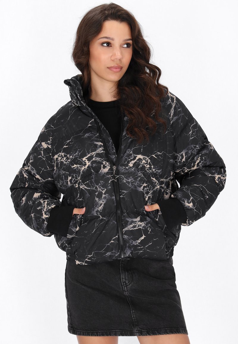 Zwarte pufferjas met een marmerpatroon en beige accenten. Rits sluiting, hoge kraag en zijzakken. Zachte, gewatteerde textuur.