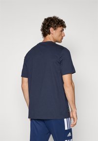 Mørkeblå bomulds T-shirt med korte ærmer, rund hals og afslappet pasform; har et diskret logo ved kanten for ekstra detaljer.