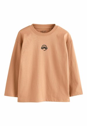 Light brown long-sleeve shirt with a crew neck. Features a small black graphic of a headset and game controller on the chest. Cotton material.