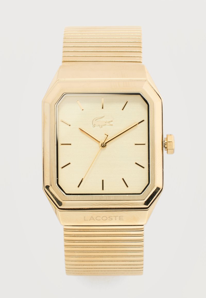 Ρολόι χειρός Lacoste σε χρυσό τόνο με τετράγωνο καντράν, ελάχιστους δείκτες ώρας, τρία χρυσά δείκτες και υφασμένη μεταλλική ελαστική μπάντα.
