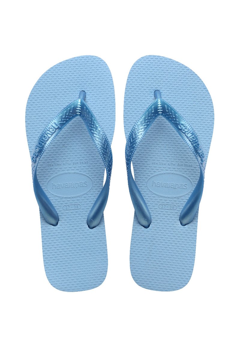 Mėlynos gumines šlepetes su plačiomis diržais ir tekstūruotu padu. Diržuose yra raštas, o prekės ženklas "Havaianas" įspaustas.