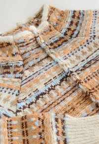 Strickpullover in Beige-, Braun- und Blautönen. Verfügt über ein geometrisches Muster mit strukturierten Garnen und einem hohen Kragen. Weiche, wollähnliche Textur.