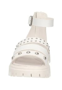 Infradito bianchi con fasce larghe, dotati di borchie in argento, cinturino alla caviglia con fibbia metallica e suola spessa e texturizzata.