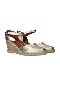 Espadrilles plateadas metálicas con tacón de cuña, con una parte superior de cuero texturizado, punta abierta y correa de tobillo ajustable. Suela envuelta en yute.