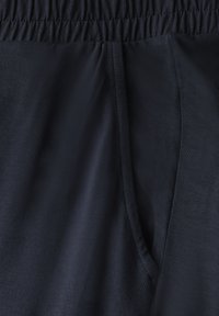 Donkerblauwe sportshorts van glad, lichtgewicht materiaal. Heeft een elastische tailleband en een trekkoord met detailing aan de zijkanten.