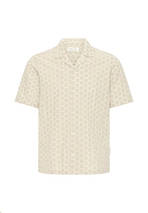Chemise beige à manches courtes avec un devant boutonné et un motif de petits œillets circulaires sur tout le tissu.
