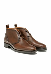 Bottines en cuir marron avec une finition lisse, dotées d'un laçage, d'un bout arrondi et de languettes sur le col, reposant sur un talon empilé.