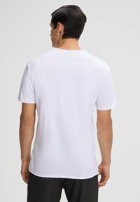 Witte katoenen T-shirt met korte mouwen, ronde hals en een relaxed fit. Soepele textuur en geen zichtbare patronen of logo's.