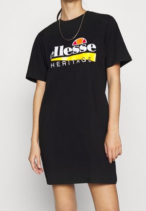 Czarna sukienka w stylu t-shirt, wykonana z bawełny, z dużym białym logo z czerwonymi i żółtymi akcentami. Krótkie rękawy i luźny krój.