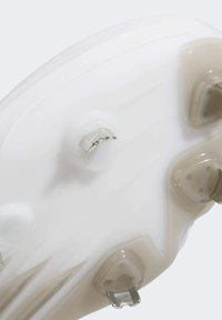 Semelle de crampons de football blanche élégante avec des crampons moulés ; présente une finition texturée et un accent argenté. Formes coniques et à lames des crampons particulièrement notables.