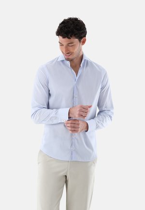 Light blue long-sleeve shirt made of cotton, featuring a pointed collar, buttoned cuffs, and a slim fit design. Smooth texture and subtle sheen.