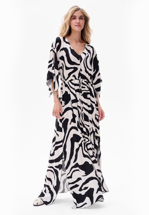 Robe maxi en tissu léger présentant un imprimé zèbre noir et blanc, avec un décolleté en V, une taille cintrée et des manches fluides.