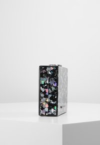 Scatola rettangolare nera con una finitura lucida e screziata, caratterizzata da accenti iridescenti; texture liscia e linee pulite su uno sfondo bianco.