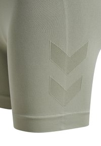 Ljust gröna träningsshorts, tillverkade av texturerat tyg. Har två präglade chevronmönster i en mörkare nyans och en åtsittande design.