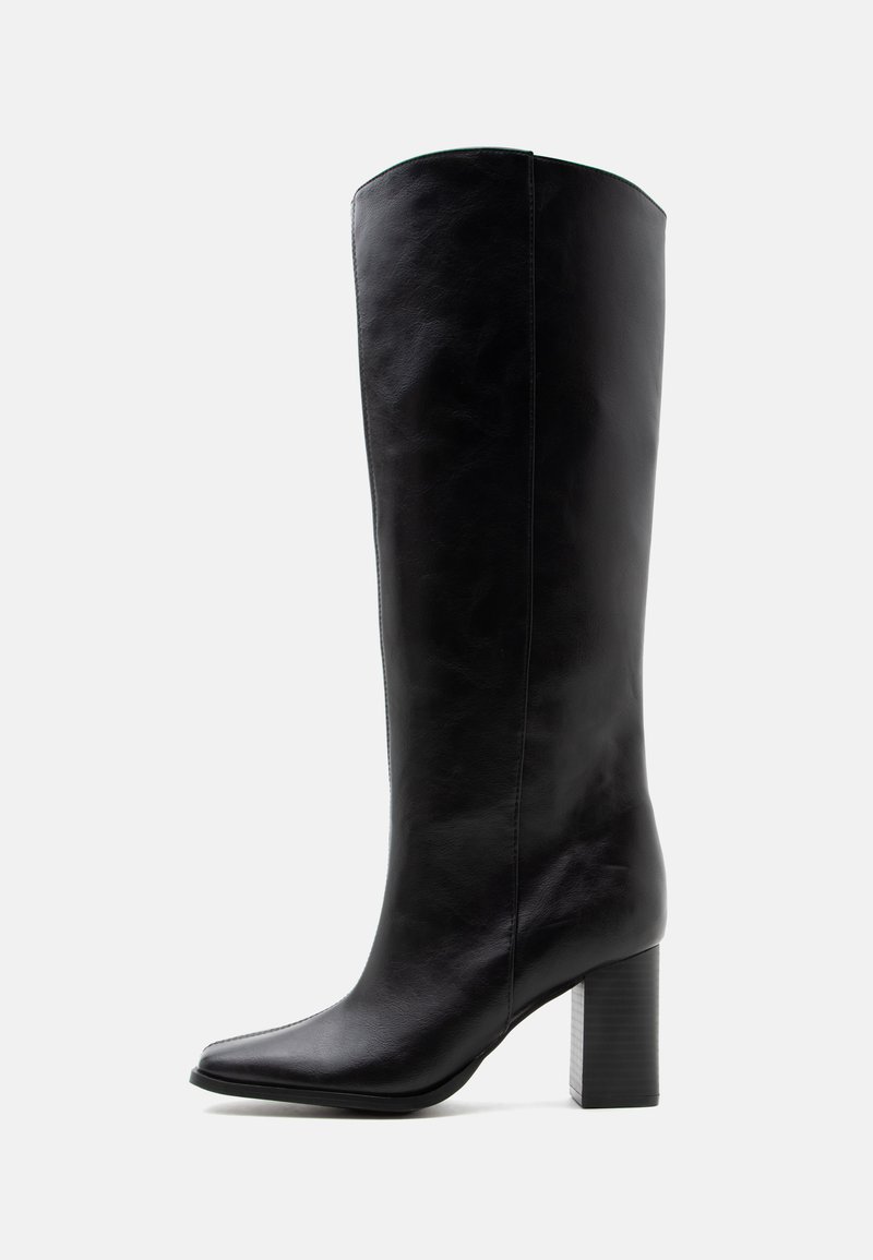 Botte noire en cuir montant jusqu'au genou avec un bout pointu et un talon bloc épais sur un fond clair uni.