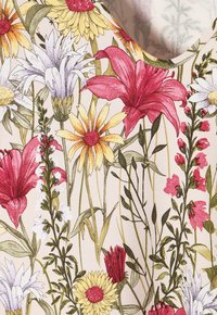 Tejido con estampado floral que presenta lirios rojos, margaritas amarillas, flores blancas y hojas verdes sobre un fondo beige claro.