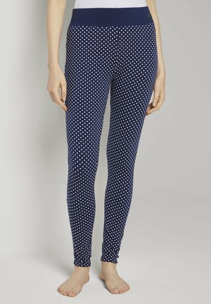 Marineblauwe leggings met witte stippen, voorzien van een brede elastische tailleband en een aansluitend ontwerp, gemaakt van een rekbare, gladde stof.